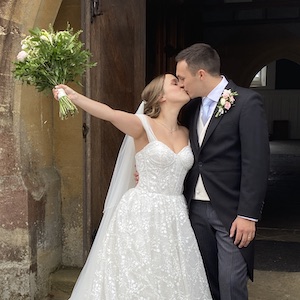 A couple kiss on their wedding day in front of St Mary's in West Malling